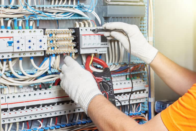 A closeup of an electrical engineer working in a power electrical panel
